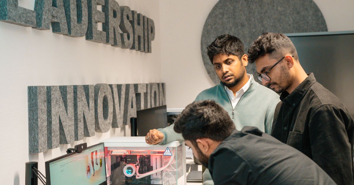 Three men collaborate in an office, focusing on tech innovation. Leadership and team dynamics emphasized.